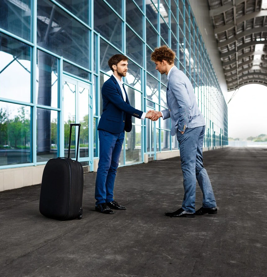 Two businessmen shaking hands at airport helped by study abroad agencies in Kerala